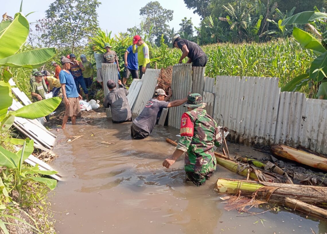 Cegah Luapan Air ke Permukiman, Babinsa dan Warga Pasang Tanggul Sungai